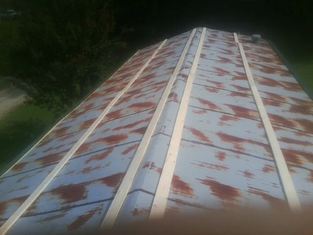 Rusted metal roof panels with new wood purlins before replacement — Storm Damage Roof Repair in Westmont by Roofing Brothers