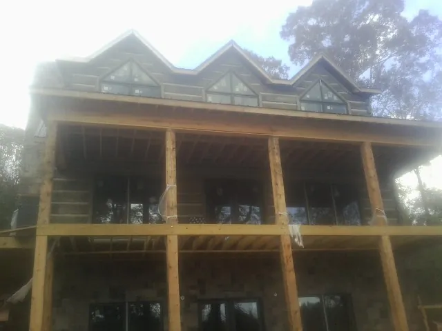 Dormers and porch framing on a large log home under construction — Roof Coating work by our crew in Westmont
