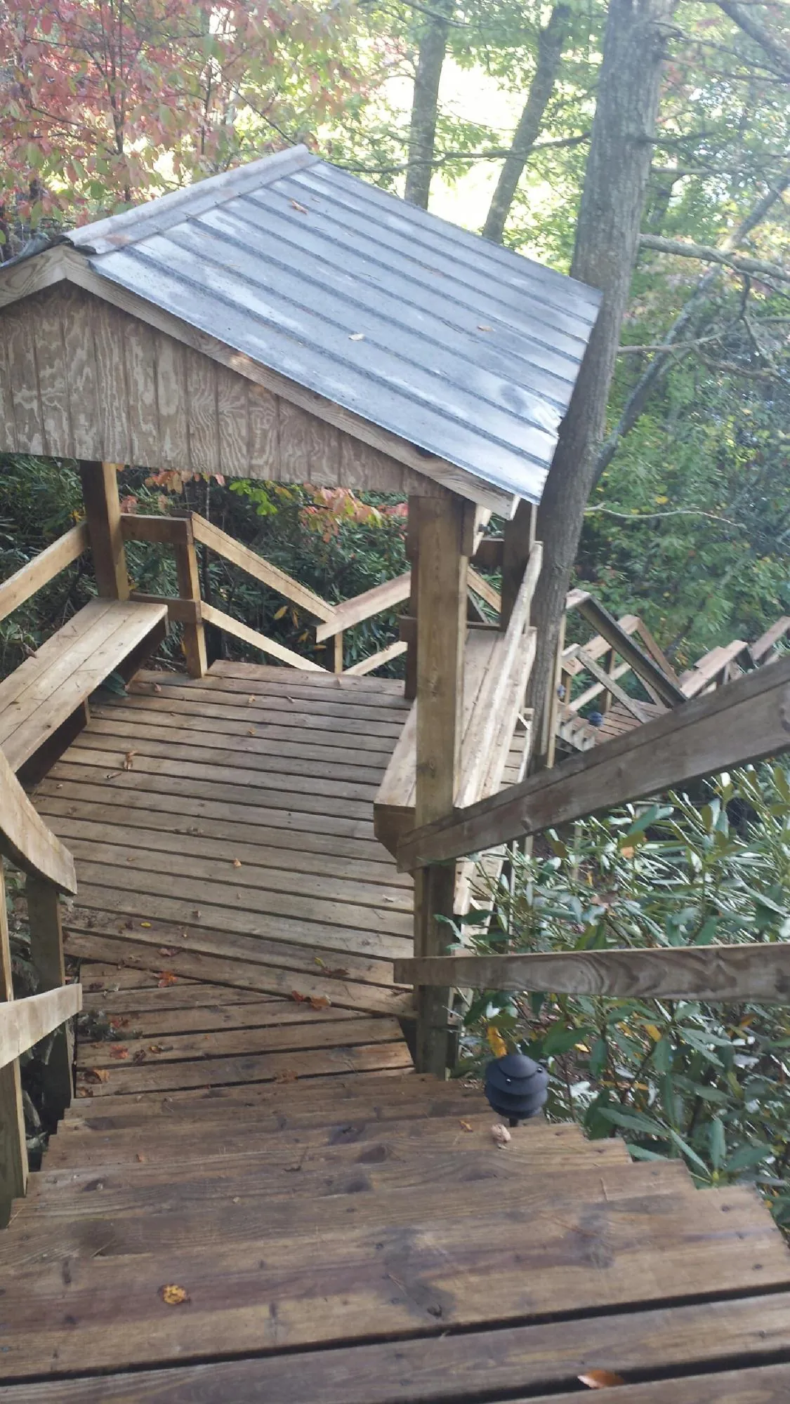 Metal roofed shelter over wooden steps on a wooded walkway — Skylight Repair & Installation work by our crew in Westmont